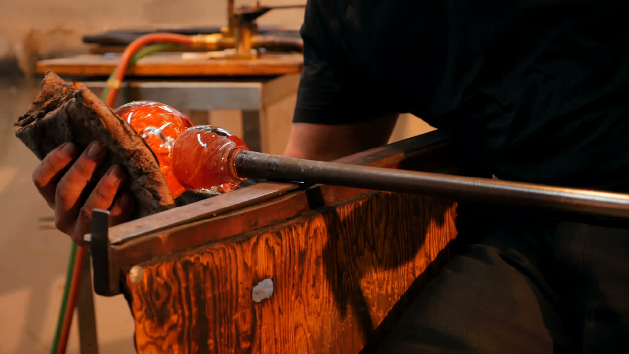 sopladores de vidrio que dan forma a un vidrio fundido