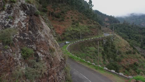car travels up on scenic panoramic route through mountain landscape, winding road, aerial