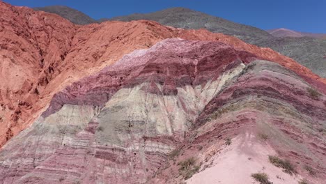 drone flight above the hills of seven colors showing red, purple, orange, lilac, ocher and beige colors in jujuy province, argentina