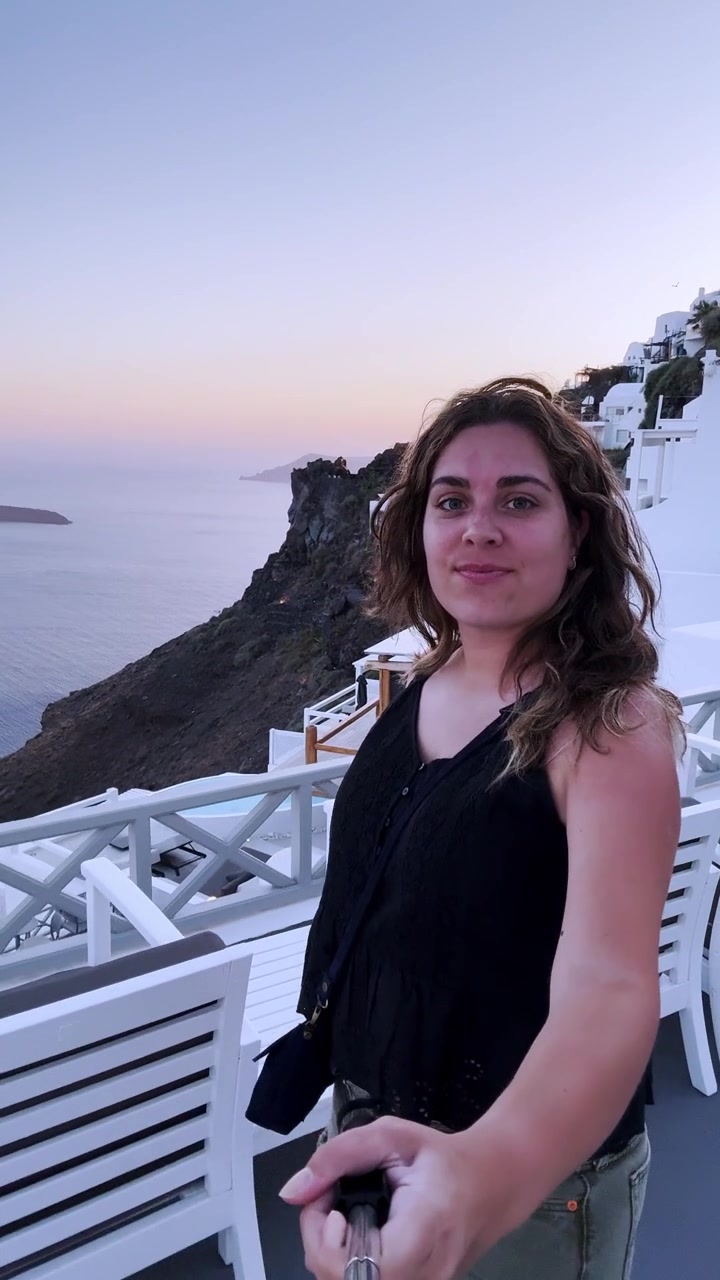 Influencer vlogging with a selfie stick in santorini, greece