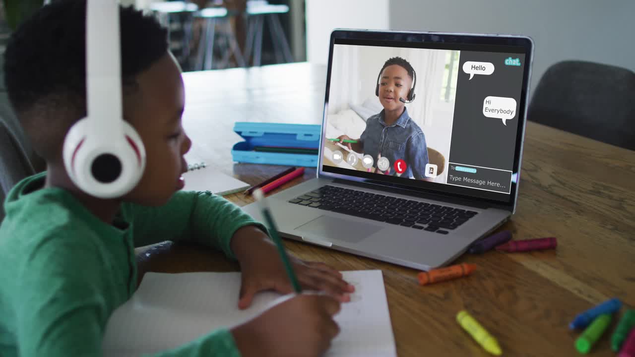 Schoolboy using laptop for online lesson at home, with his colleague and web chat on screen
