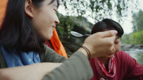 asian female tourists eating meal at camp