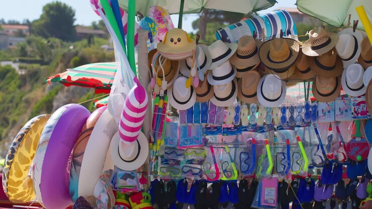 Barraca vibrante de um vendedor de praia em Guidaloca, Sicília, vendendo chapéus de sol e brinquedos