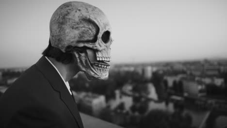 person in skull mask overlooking city