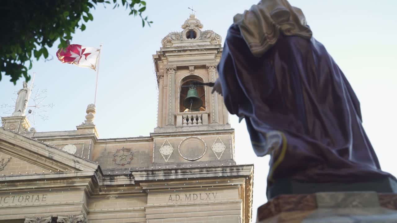 campana de la iglesia sonando durante una celebración en malta - bandera ondeando