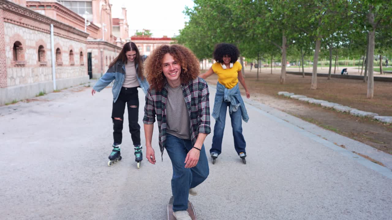Adolescenti sullo skateboard e sui pattini a rotelle nel parco