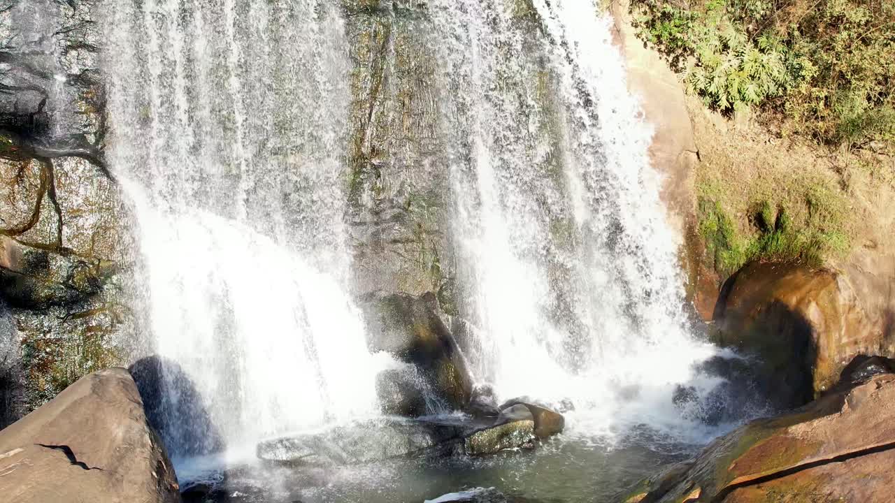 cámara que captura una cascada de abajo hacia arriba con un enfoque principal en la piscina de inmersión