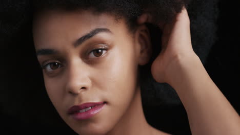 close-up-portrait-attractive-african-american-woman-touching-face-with-hands-caressing-smooth-healthy-skin-complexion-enjoying-perfect-natural-beauty-funky-afro-on-black-background