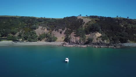 Antena,-Volando-Lejos-De-Un-Barco-De-Pesca-Con-Playa-Y-Montaña-Como-Fondo-En-Un-Hermoso-Día-Soleado,-4k