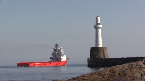 aberdeen harbour with ship leaving past lighthouse on a sunny day