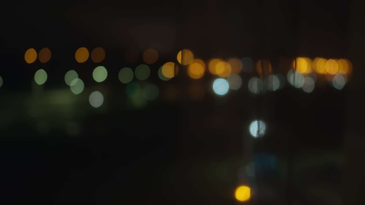 luces de colores borrosos de la ciudad de la noche de la ventana abierta, detrás de las cortinas de