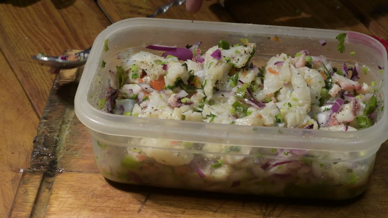 primer plano de ceviche fresco con aceite de oliva añadido, mesa de madera rústica