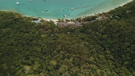 Panorámica-Aérea-De-Drones-Sobre-El-Complejo-De-La-Isla-Fitzroy-Y-Barcos-En-El-Agua-Transparente-Azul-Tropical-En-Un-Día-Soleado