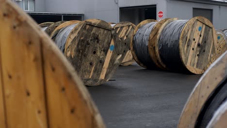 un montón de bobina de madera de cable que se encuentra en el patio de la fábrica de cables, está preparado para la carga.