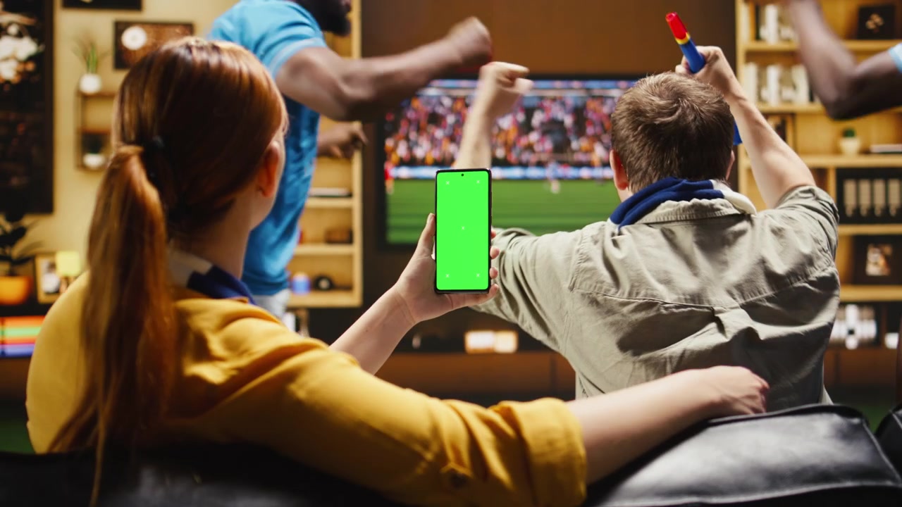 Smartphone mockup usato da tifosi di calcio allegri sul divano che festeggiano un gol