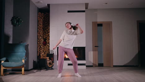 mujer bailando en casa junto a la chimenea