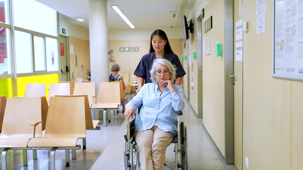 Nurse Assisting Elderly Patient in Hospital Wheelchair