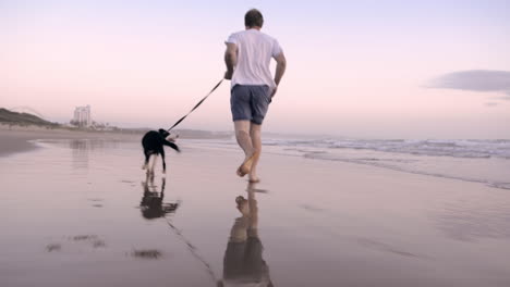 Happy-man-running-dog-on-beach-lifestyle-steadicam-shot