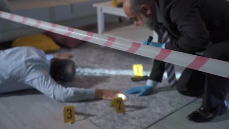 la policía está llevando a cabo investigaciones forenses de la víctima asesinada en el apartamento.