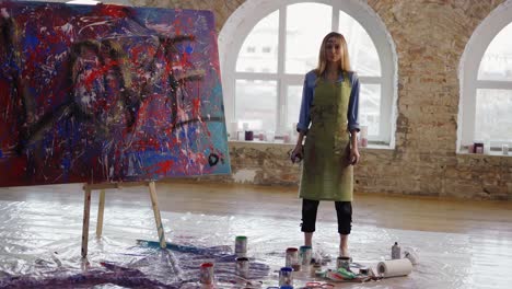 portrait female painter after finishing her painting in art studio