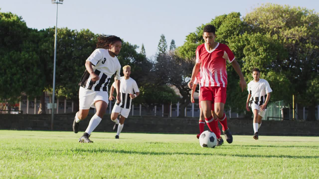 video de un grupo diverso de jugadores de fútbol masculino en el campo, jugando fútbol