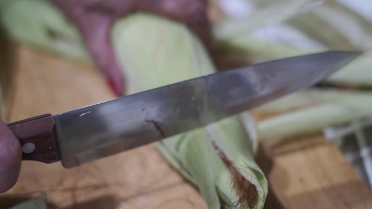 manos pelando una mazorca de maíz fresca, mazorca de maíz, quita la cáscara de la mazorca, cierra