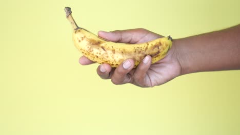 hand holding a slightly bruised banana