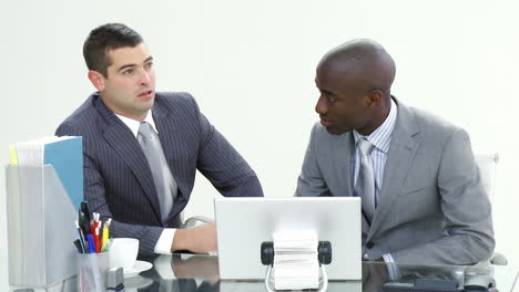 two businessmen working with a laptop in office