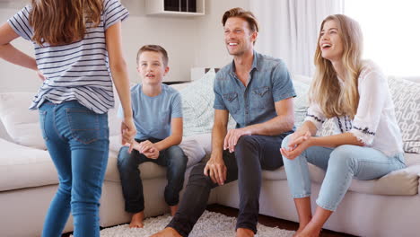 familia sentada en el sofá en casa jugando a las charadas en cámara lenta