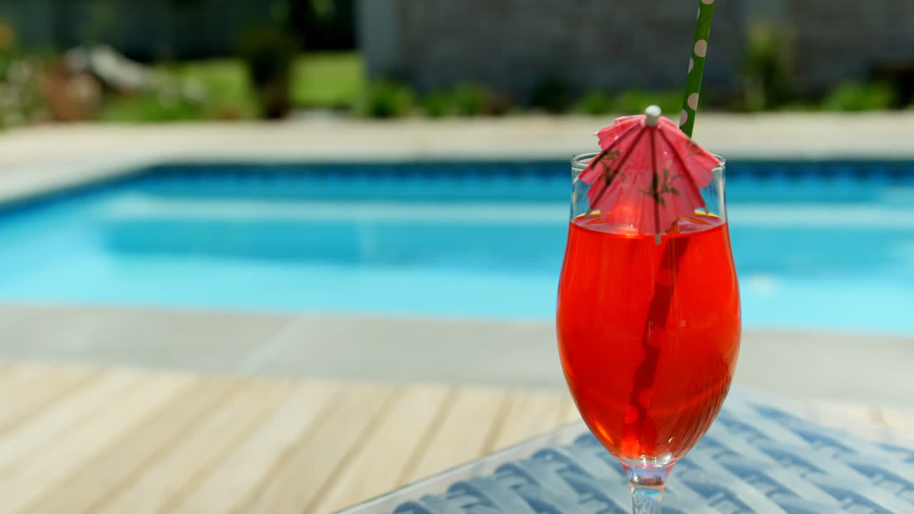 Nahaufnahme eines Cocktails auf einem Tisch am Schwimmbad 4k