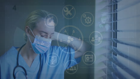 animation of digital icons data processing over caucasian female doctor in face mask