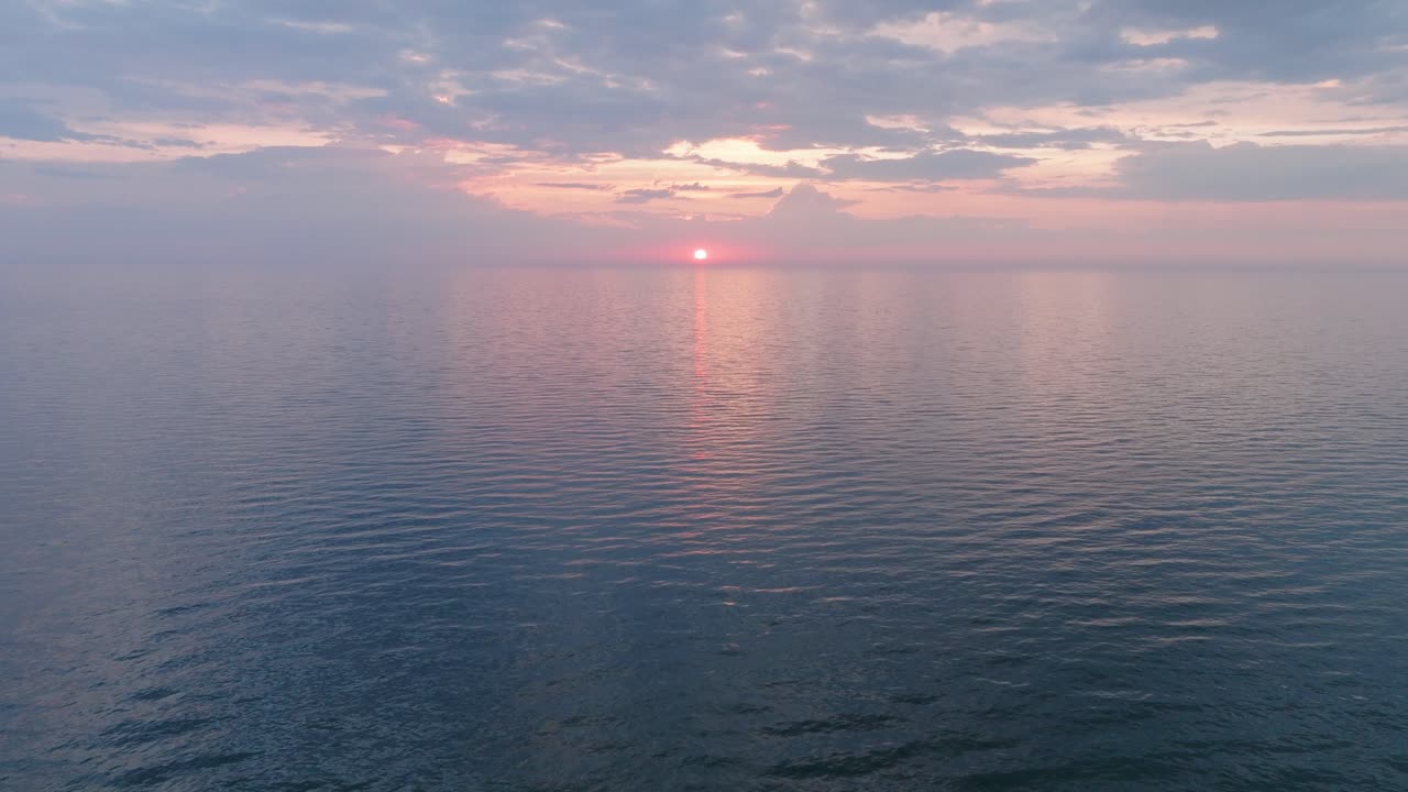 평온한 발트해 위의 활기찬 높은 대조적인 일몰의 아름다운 공중 전망, 지평선에 구름, 카로스타 전쟁 항구 콘크리트 해안 요새 폐허 리파자, 넓은 드론  ⁇  앞으로 이동