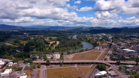 Willamette-River-On-A-Summer-Day-In-Eugene,-Oregon-With-Distant-View-Of-Autzen-Stadium-In-Background---aerial