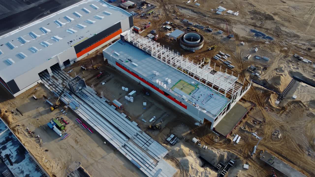 drone aéreo disparado sobre un nuevo sitio de desarrollo de construcciones proyectos de almacenes y maquinaria pesada y trabajadores de la construcción están trabajando en el área.