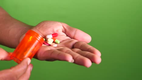 close up of man hand taking medicine on green screen