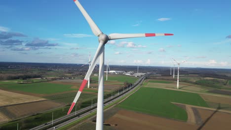 wind turbines next to highway provide electricity for charging electric vehicles