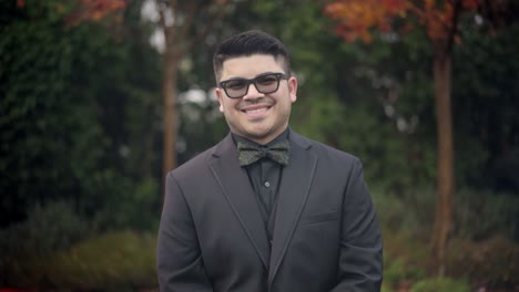 el novio se abotona mientras sonríe para la cámara.