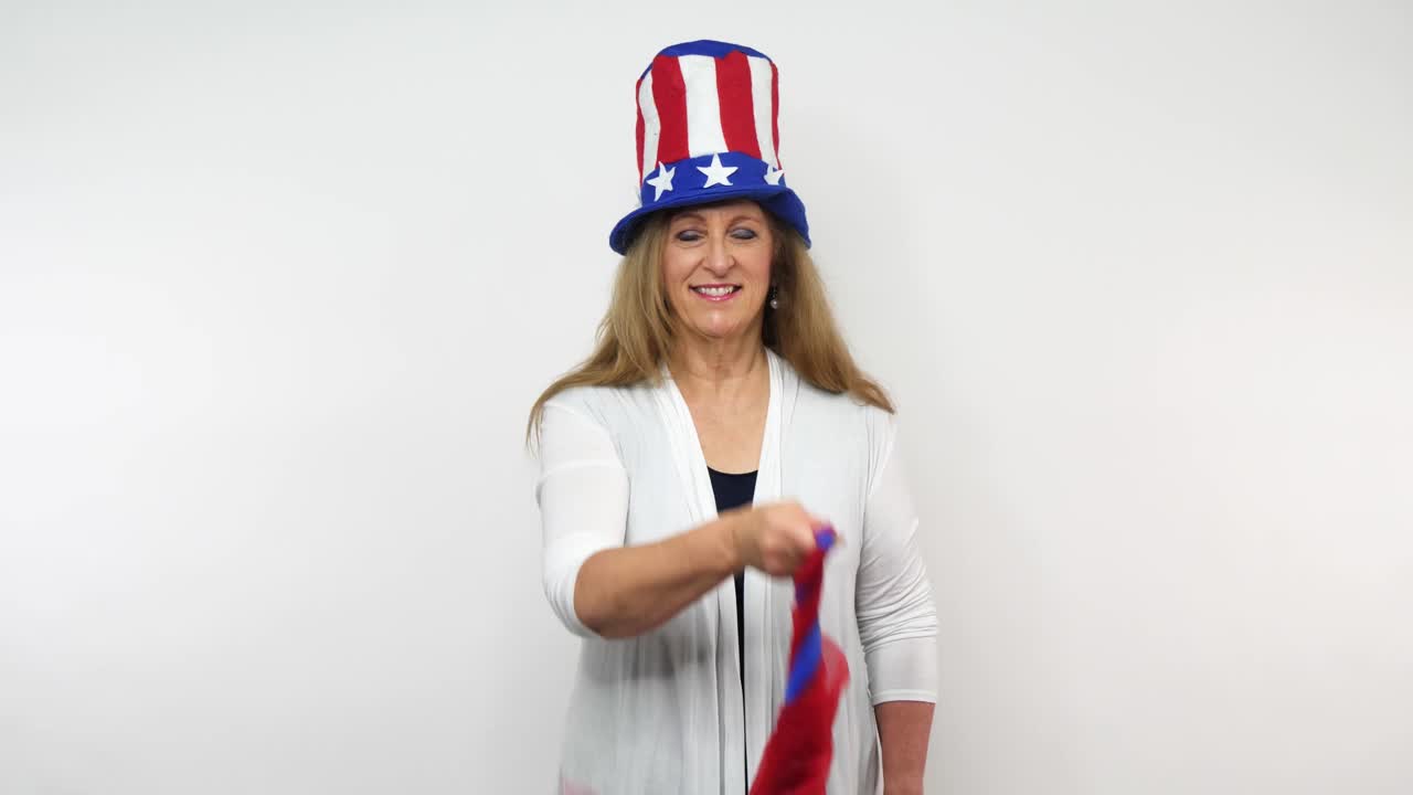 원로 여성은 애국적인 옷을 입고 원 안에 빨간색과 파란색 스카프 한 켤레를 소용돌이