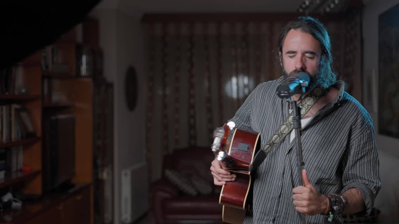 hombre cantando y tocando la guitarra acústica