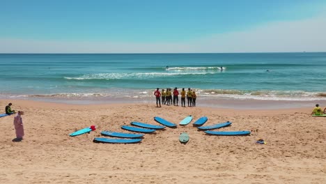 aerial: surf school class on beach in sydney australia. surfboards in the sand, holiday aerial video