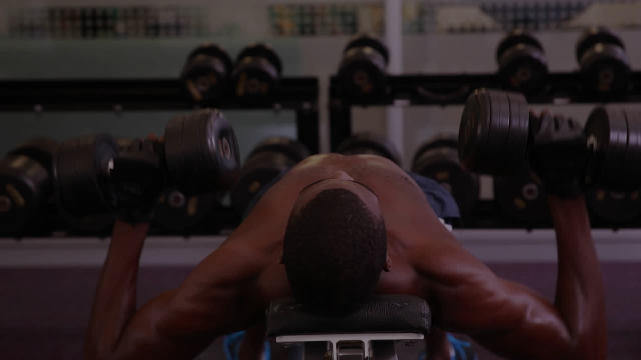 Man starting dumbbell set by lifting fitness weights, doing firm chest presses with code overlaying