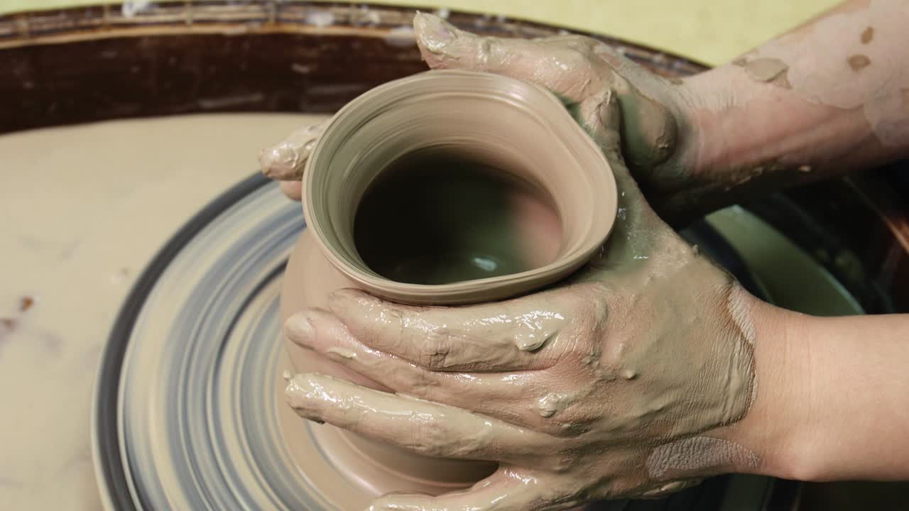 Woman hands on pottery wheel. Craftsman artist shapes pot