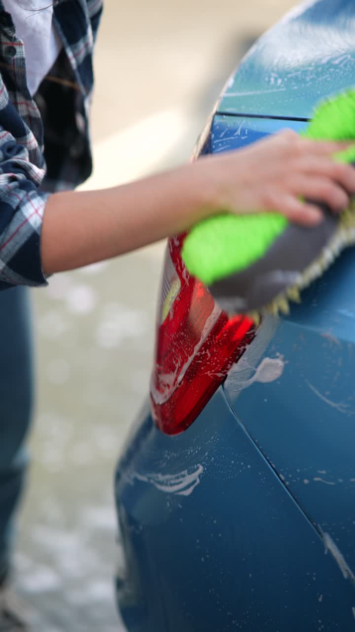 mujer lavando un coche azul