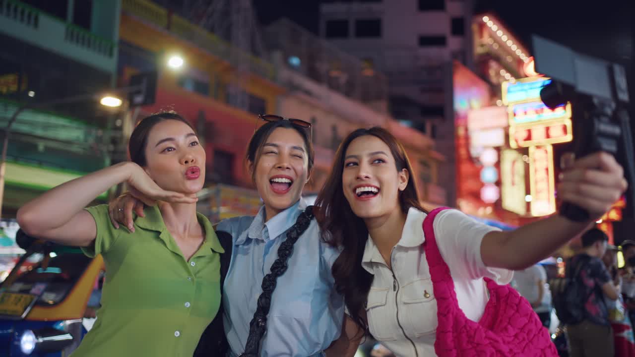 활기찬 야간 시장에서 셀카를 찍는 행복한 친구들