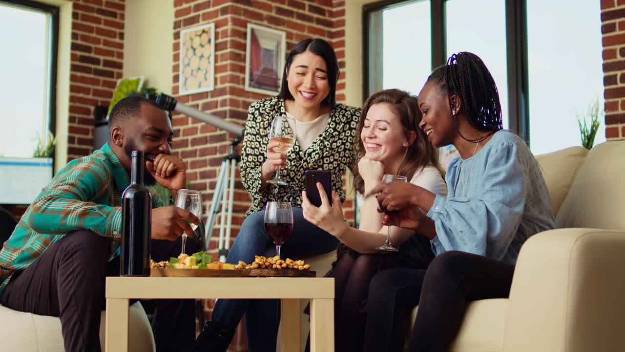 Friends at reunion looking at funny videos from their childhood on smartphone screen