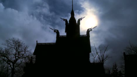 the sun shines behind a spooky stave church in norway;