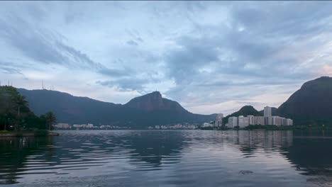Time-lapse-at-early-morning-blue-hour-sunrise-showing-the-clouds-pass-by-and-water-of-the-city-lake-moving-in-the-wind-in-Rio-de-Janeiro-prestigious-Lagoa-neighbourhood