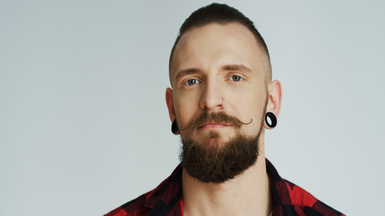 hipster ofendido enojado mirando a la cámara y asintiendo con la cabeza