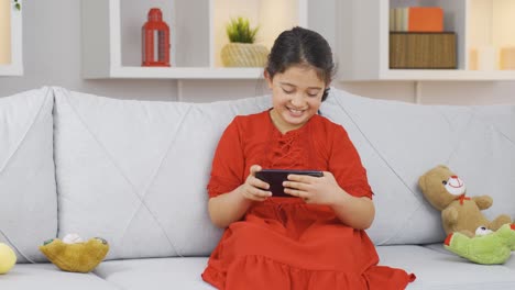 Girl-child-plays-games-on-the-phone-at-home.