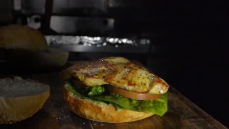 grilled chicken breast falls on burger, slow motion